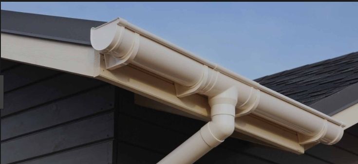 Rainwater flowing off a roof without gutters, causing erosion near the foundation.